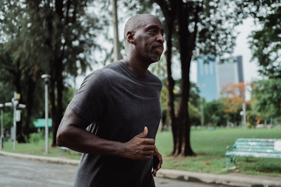 A man jogging in a city park, a habit that lowers heart risk for men over time