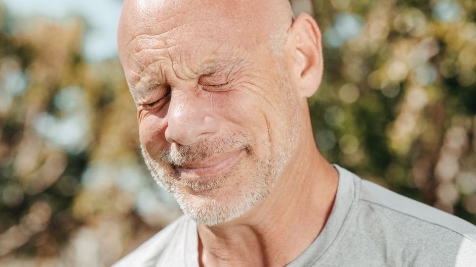 A man pausing to relax outdoors, easing stress that affects heart health in men